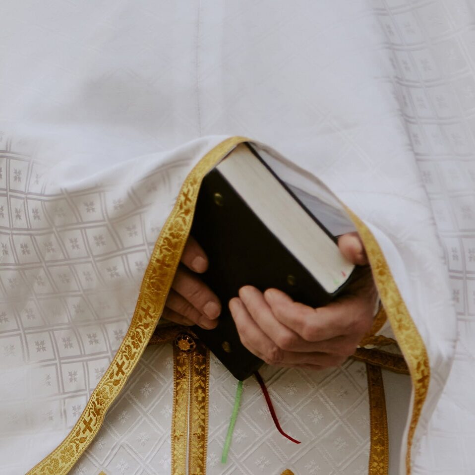 Priest standing with bible